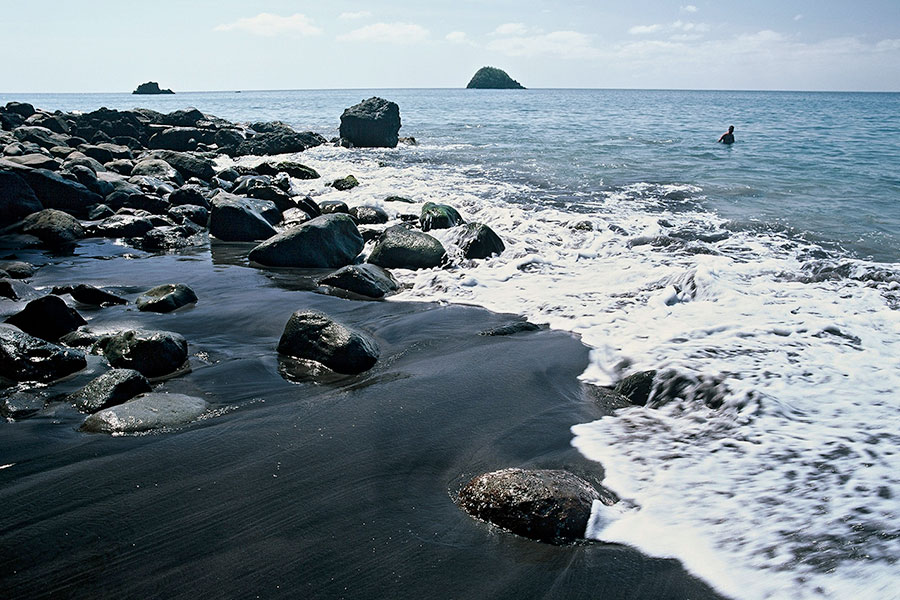 Dark sand beach with sand and rocks